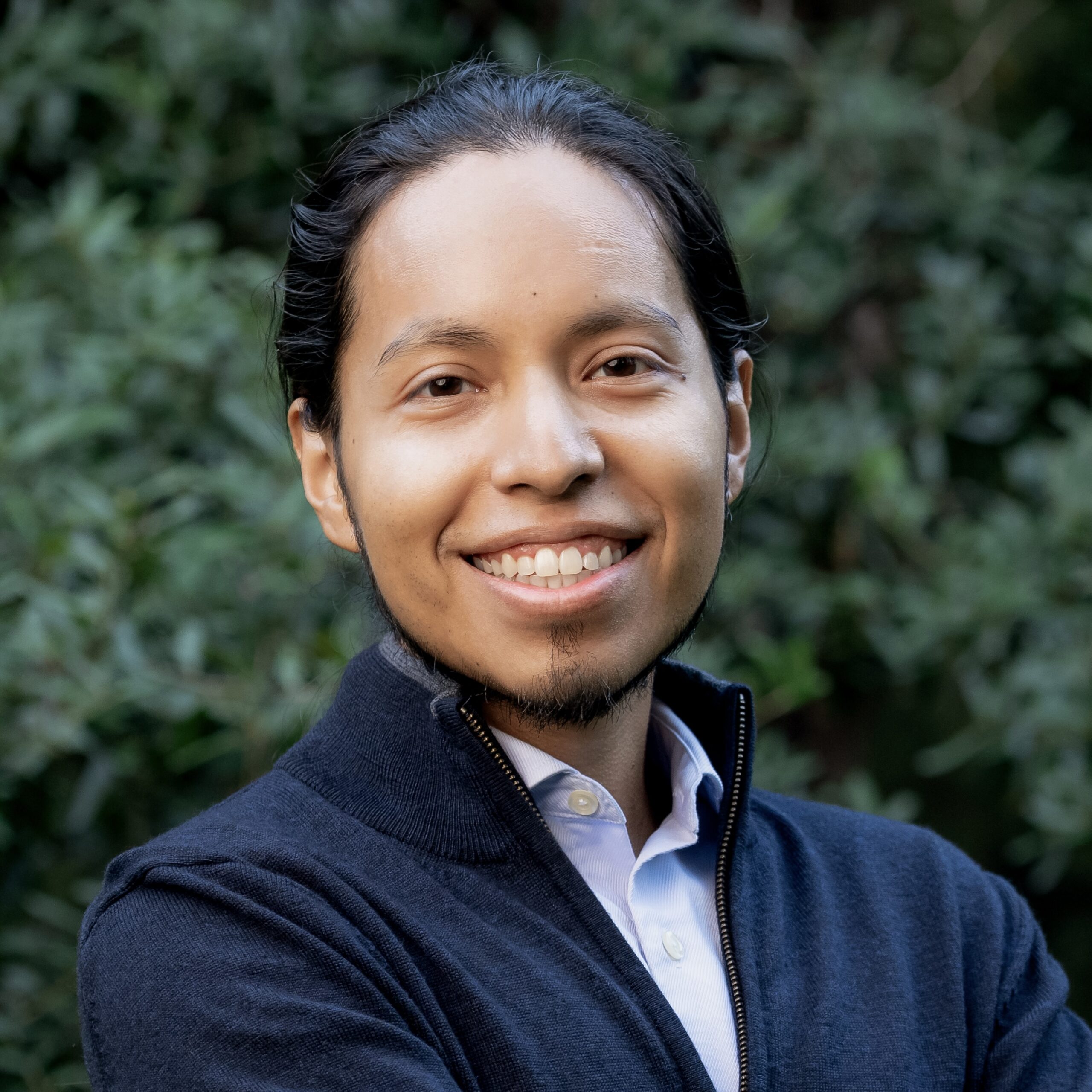Picture of Uriel Guadarrama in front of greenery.